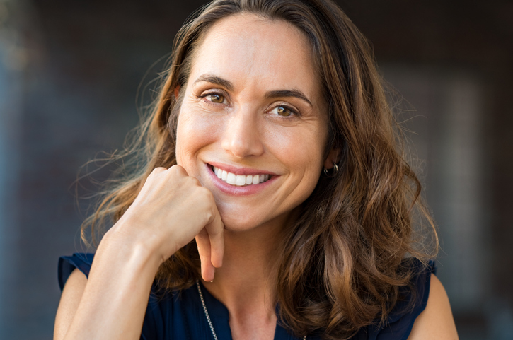 Woman leaning against her hand while smiling into camera
